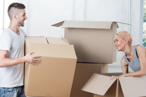 Removalists handling household items in a typical Edgware property with stairs
